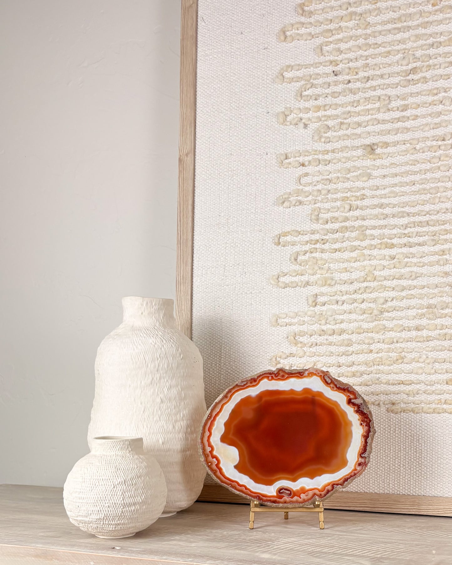“Natural agate slice from Brazil displayed on stand with intricate mineral banding and crystal texture.”