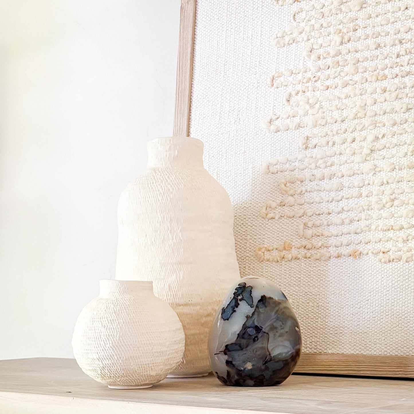 Luxury fern agate crystal sculpture with botanical-like inclusions on neutral styled shelf