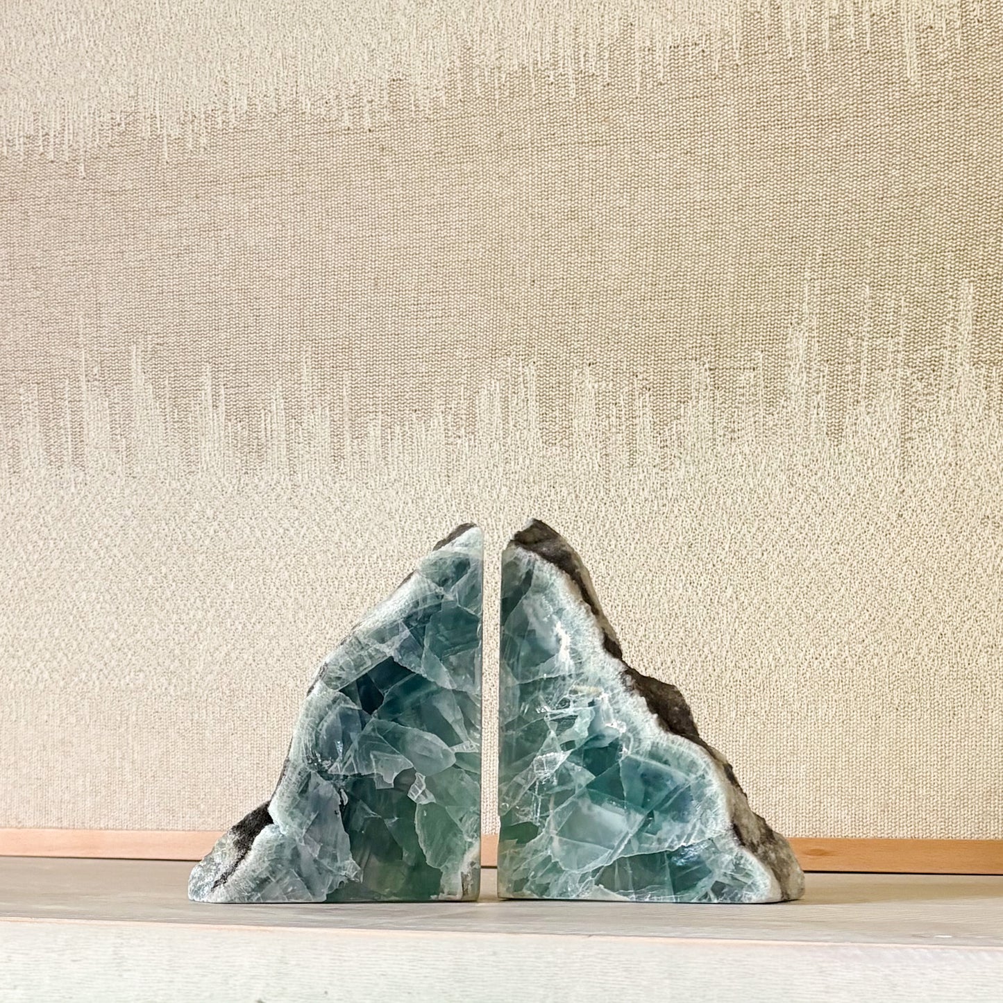 Sculptural fluorite bookend pair styled in warm neutral interior design
