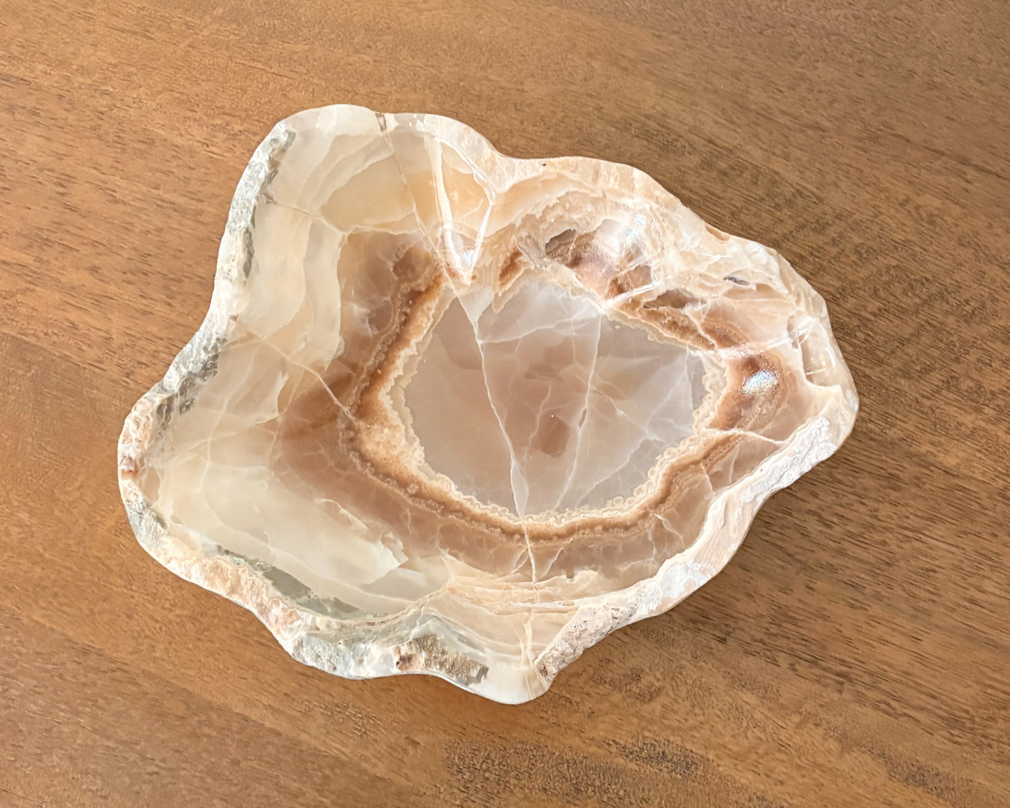 Polished amber onyx bowl with translucent golden brown coloring