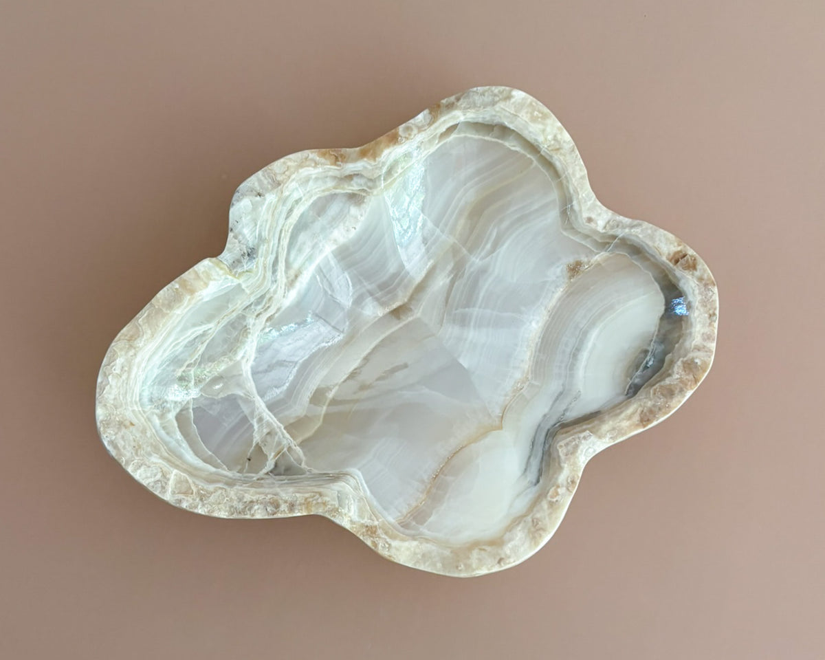 Decorative amber onyx bowl with distinctive natural banding and translucent honey-colored tones, hand-carved from solid stone