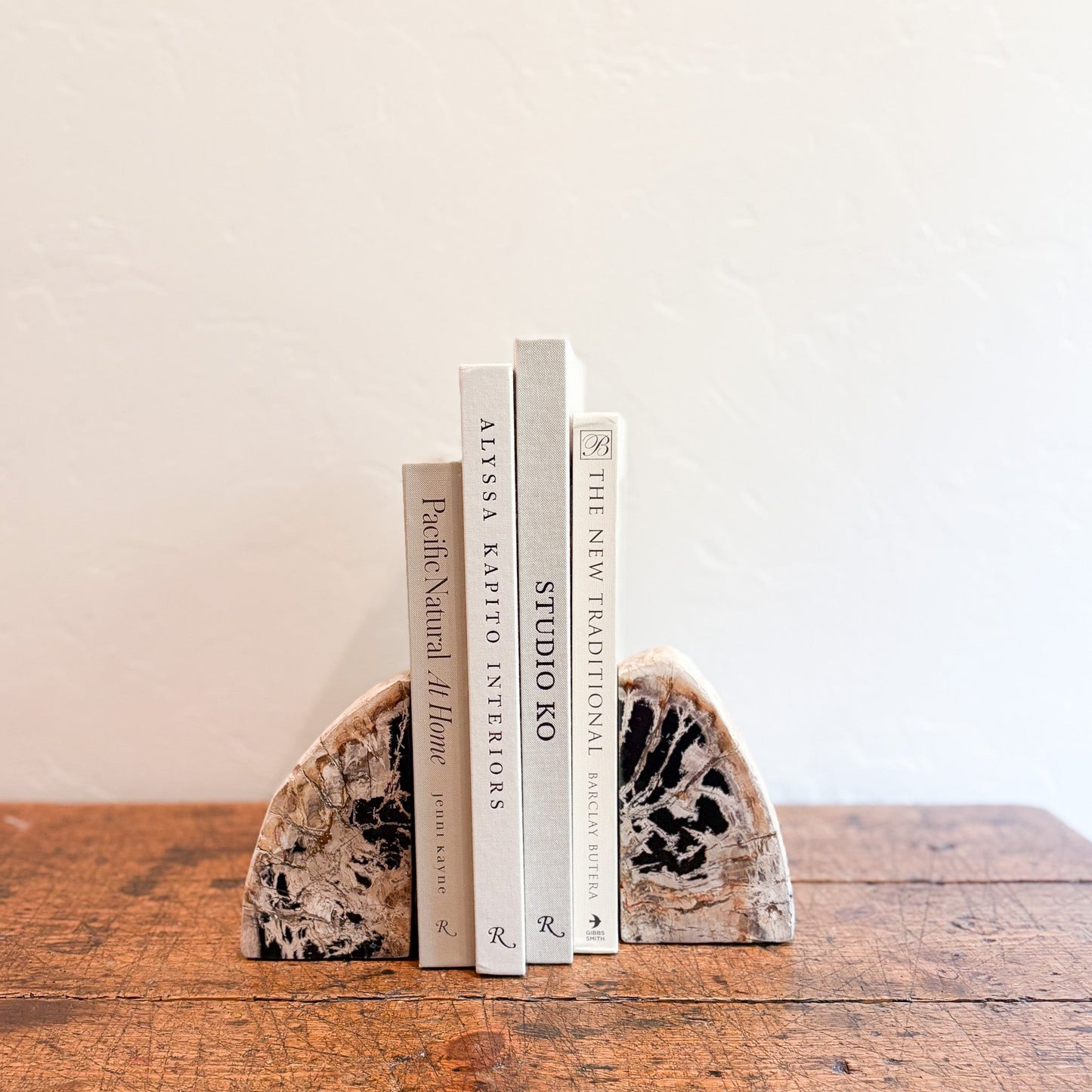 Geode bookends holding books on a wooden surface with a plain background