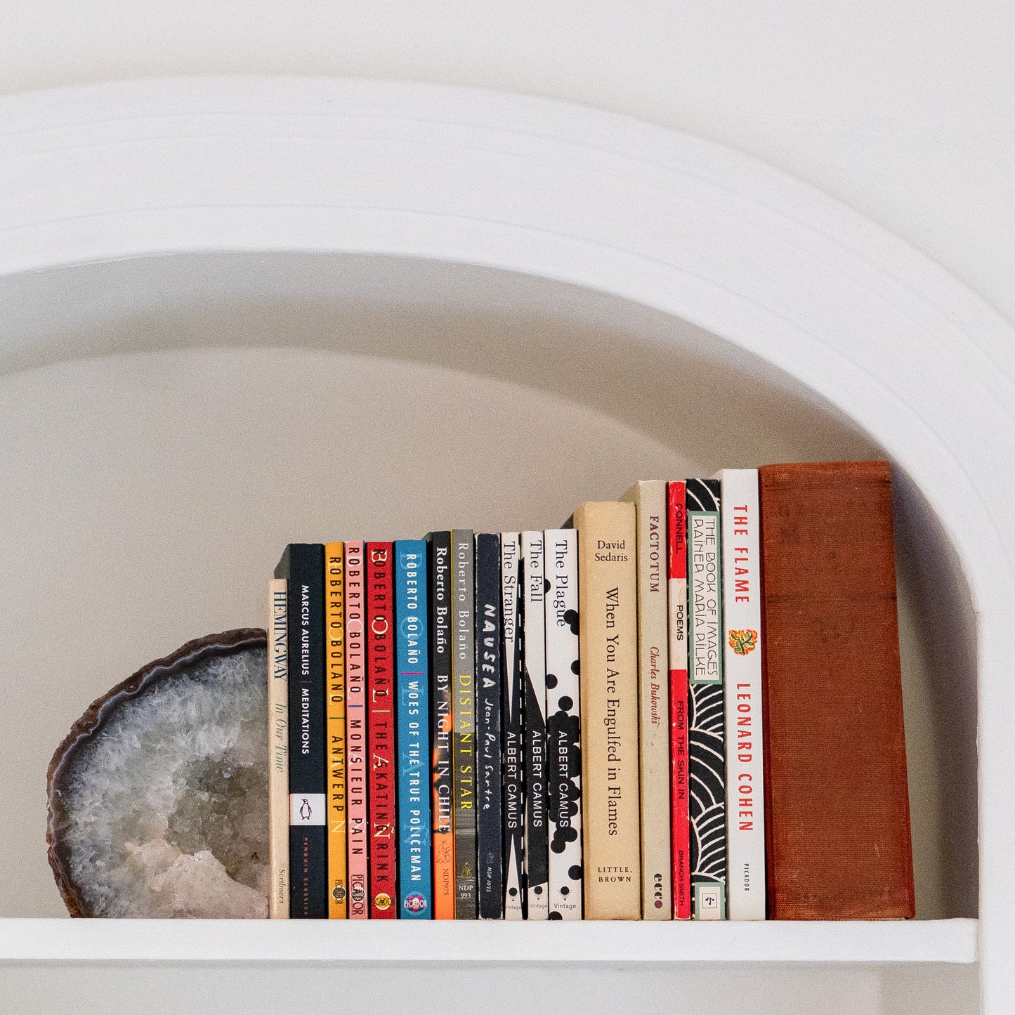 Natural blue agate druzy bookends with polished edges showcased on white built-in shelving.