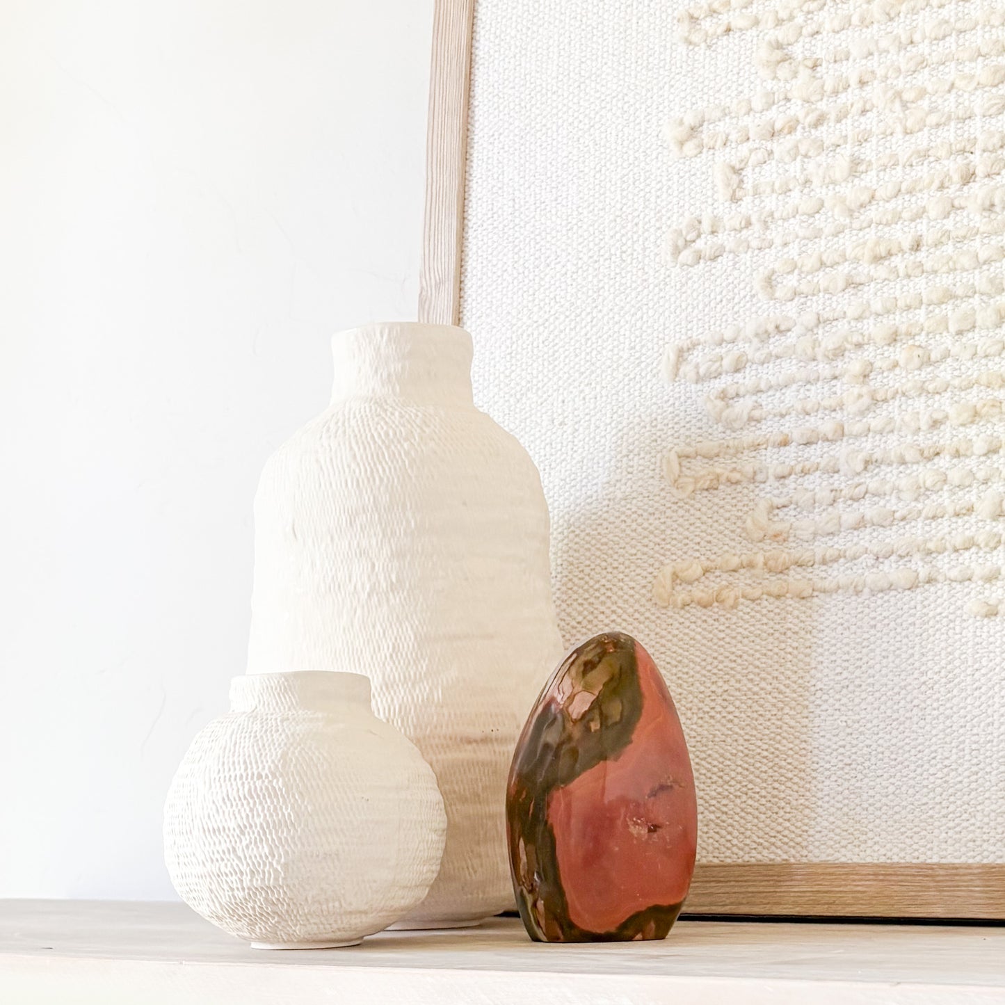 Polychrome jasper sculpture styled on modern shelf with minimalist home decor