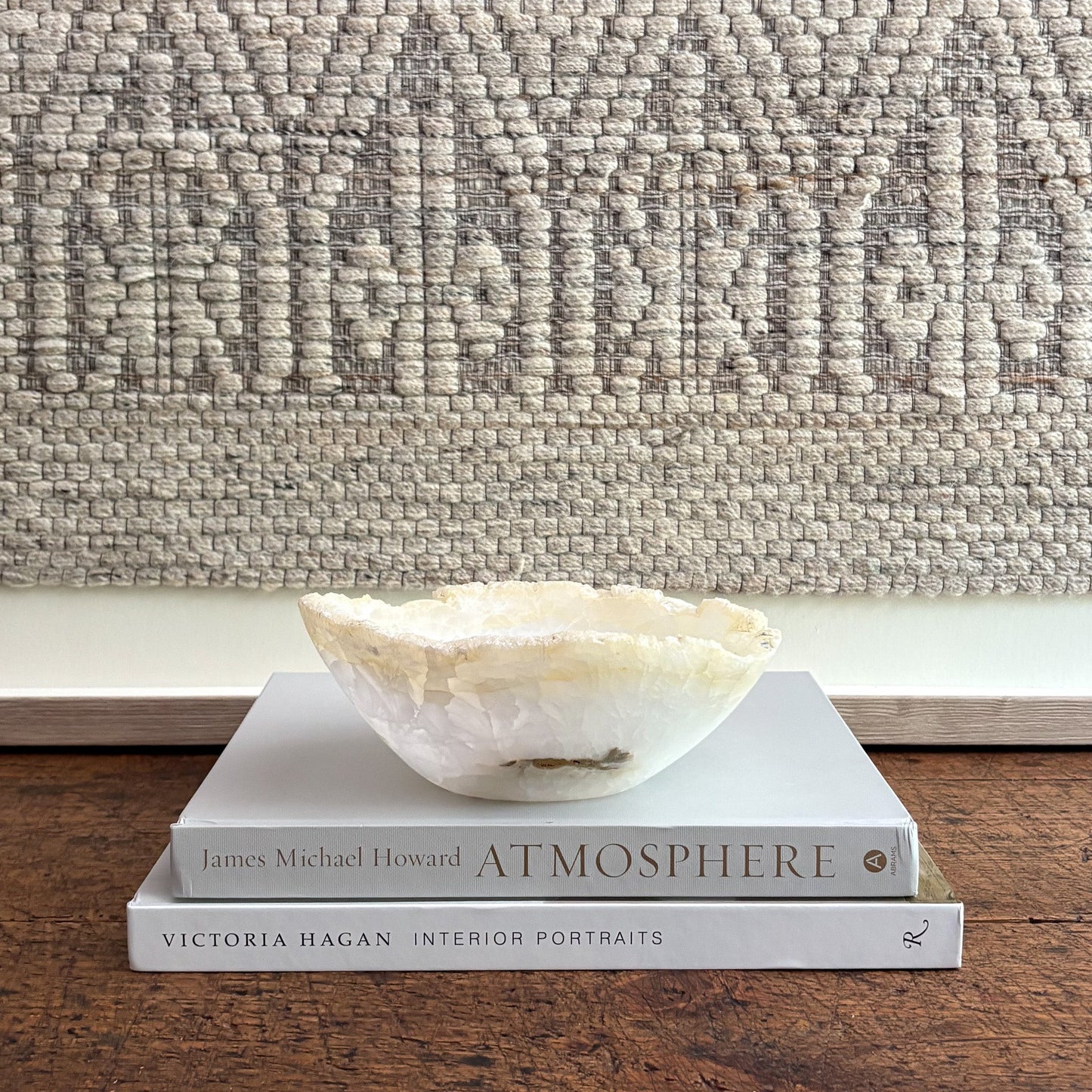 Decorative bowl on books with a textured wall in the background