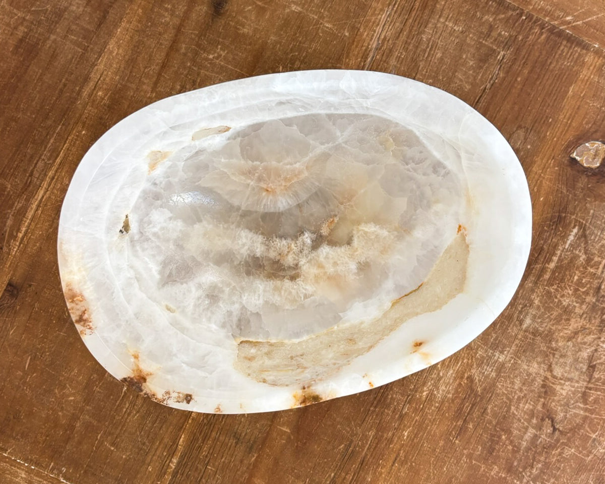 Small decorative amber onyx bowl featuring sculptural form and polished interior