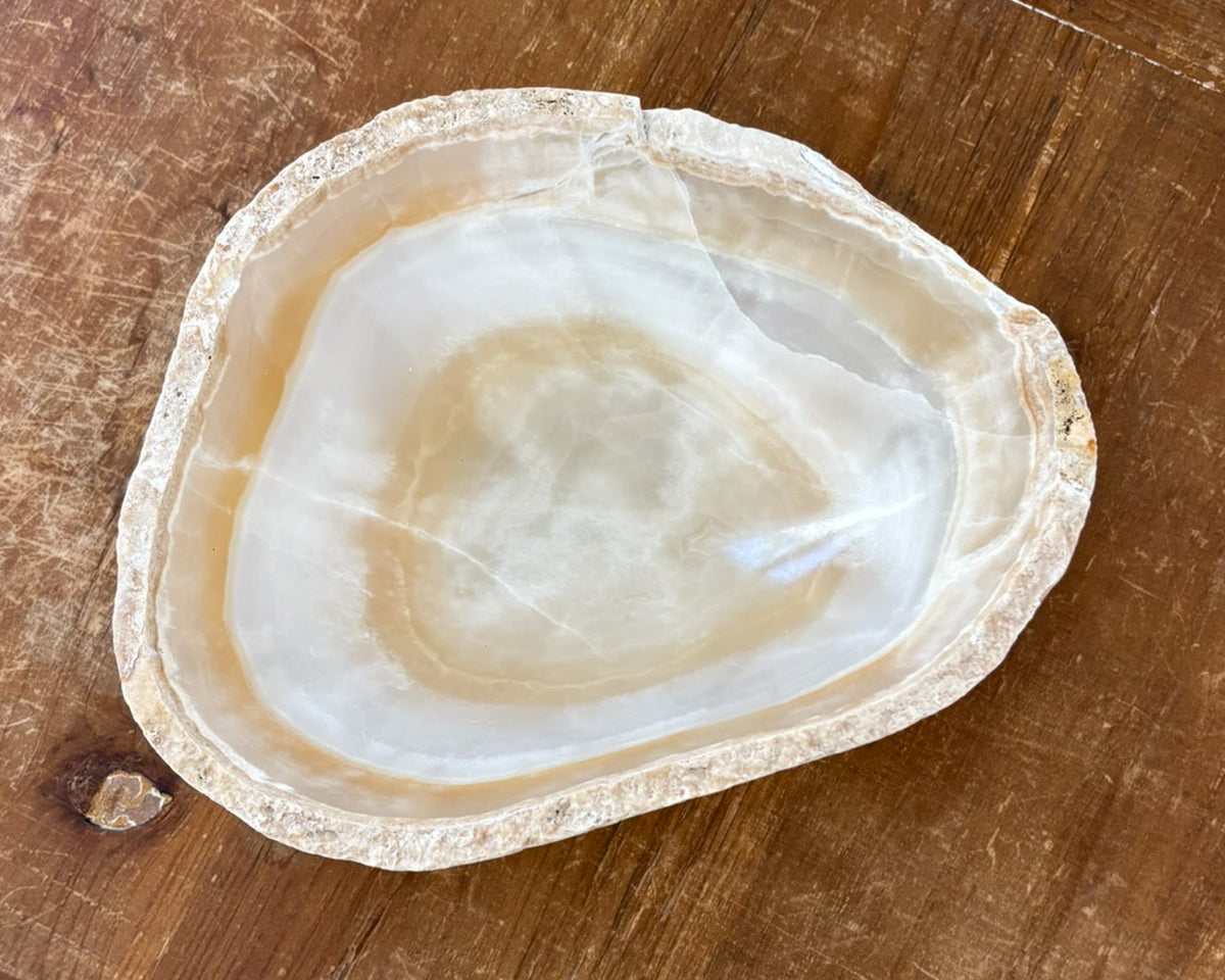 Small decorative amber onyx bowl featuring sculptural form and polished interior