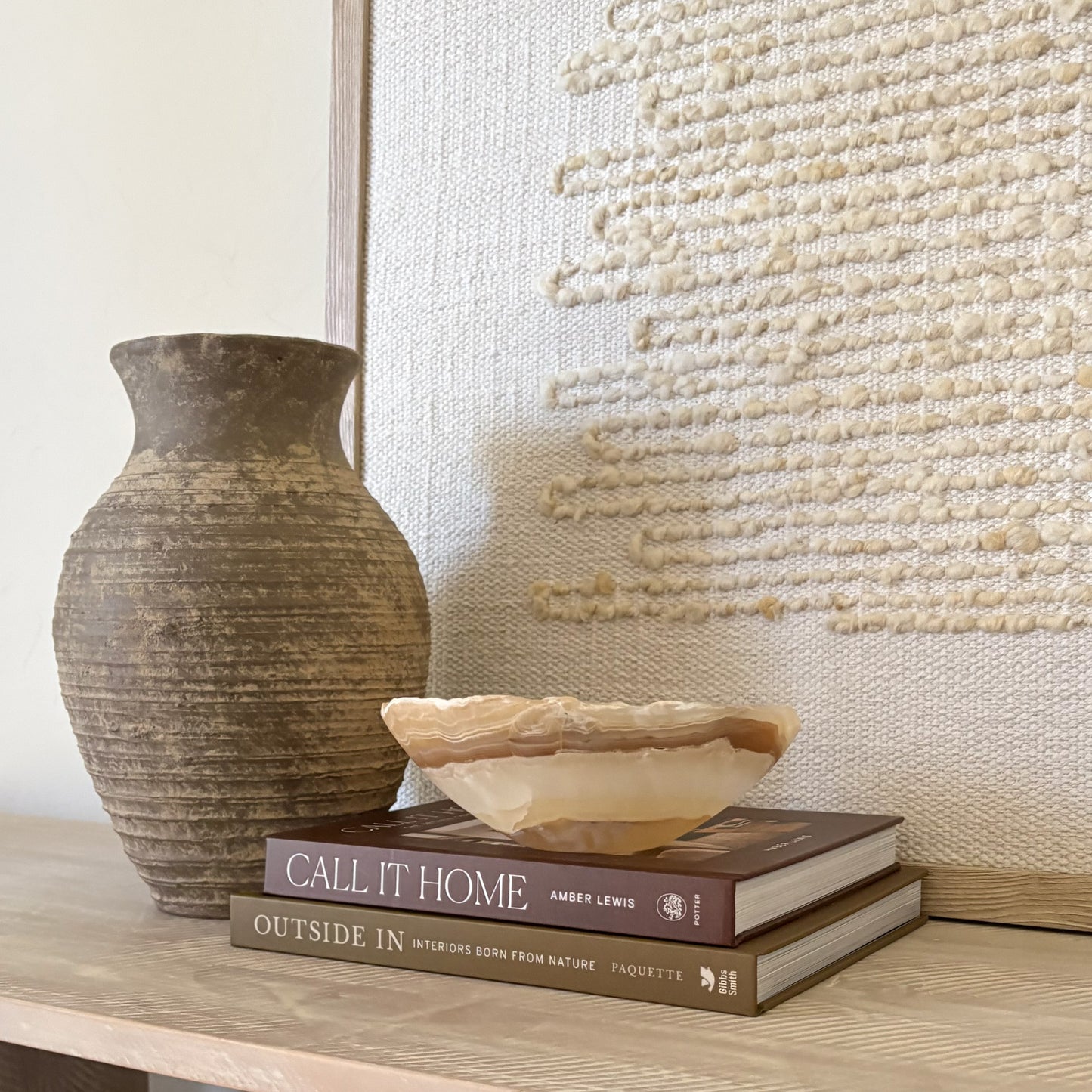 Small amber onyx bowl styled on wooden surface with neutral wall art