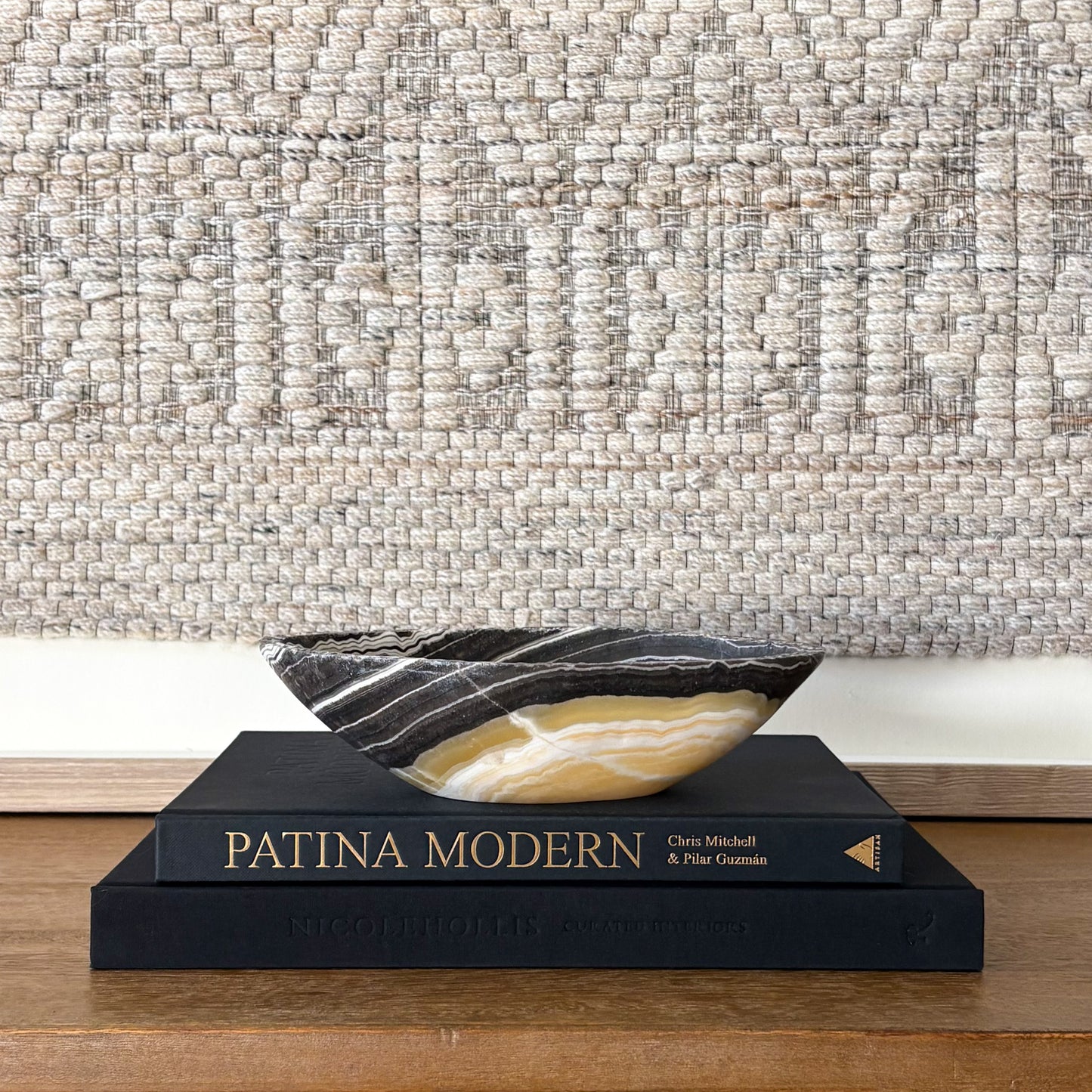 Small zebra onyx decorative bowl with natural striped stone pattern on wooden console