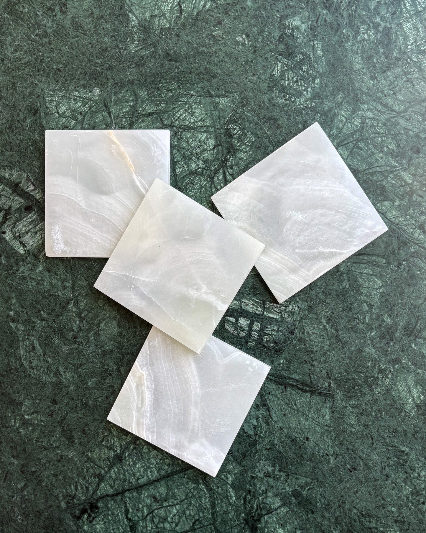 Authentic white onyx stone coasters with distinctive veining and polished edges