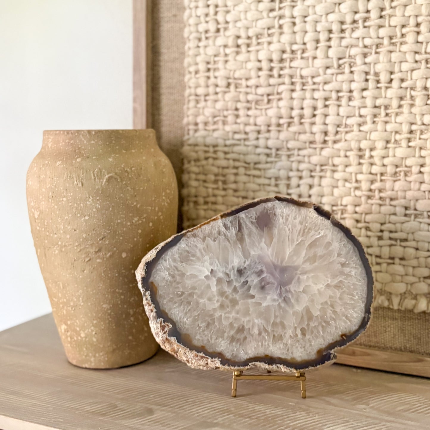 Large Brazilian agate slab on metal stand with natural crystal banding and polished gemstone surface