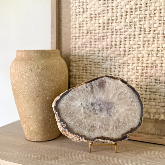 Large Brazilian agate slab on metal stand with natural crystal banding and polished gemstone surface
