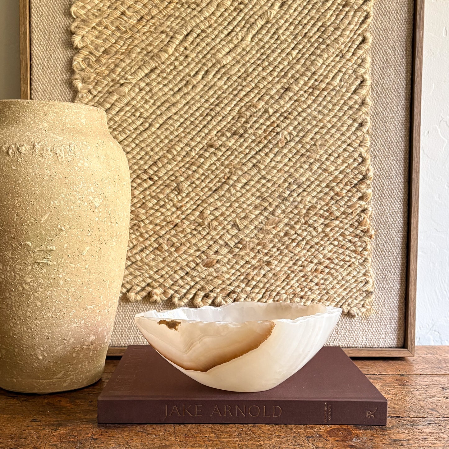 Decorative natural stone bowl on a book with a textured wall in the background