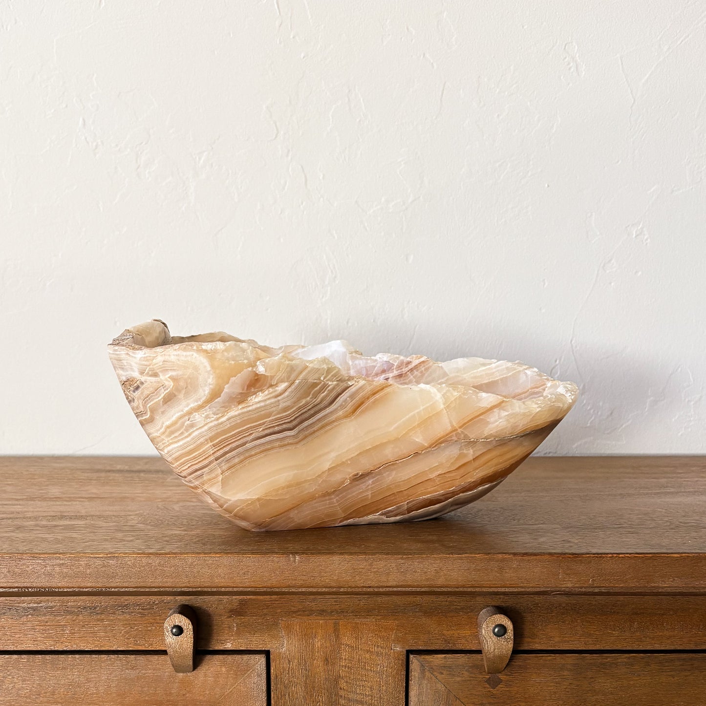 Artisan carved amber onyx stone bowl with organic veining and sculptural shape