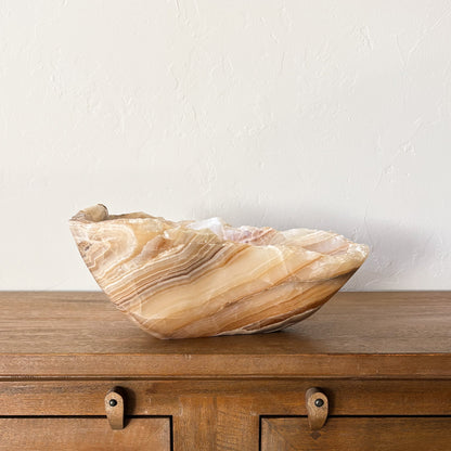 Artisan carved amber onyx stone bowl with organic veining and sculptural shape