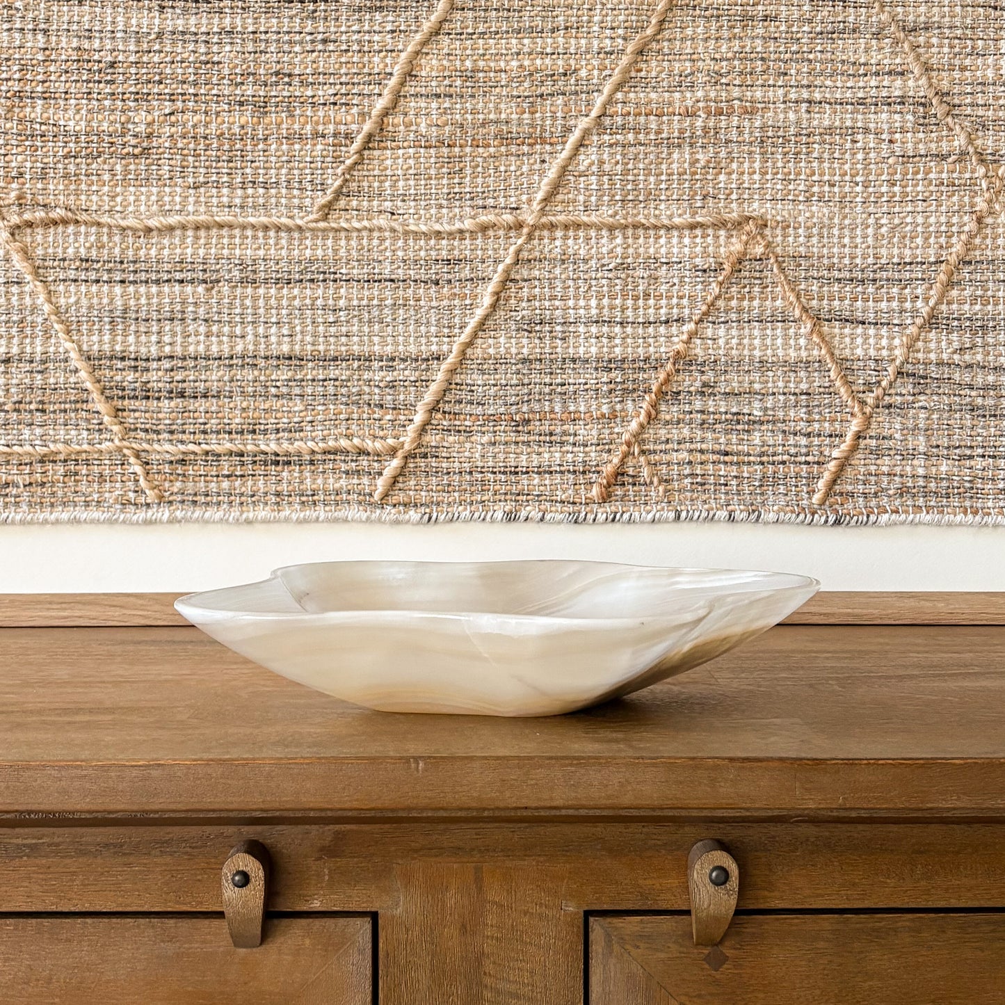 Large hand carved amber onyx bowl with organic shape on wooden table