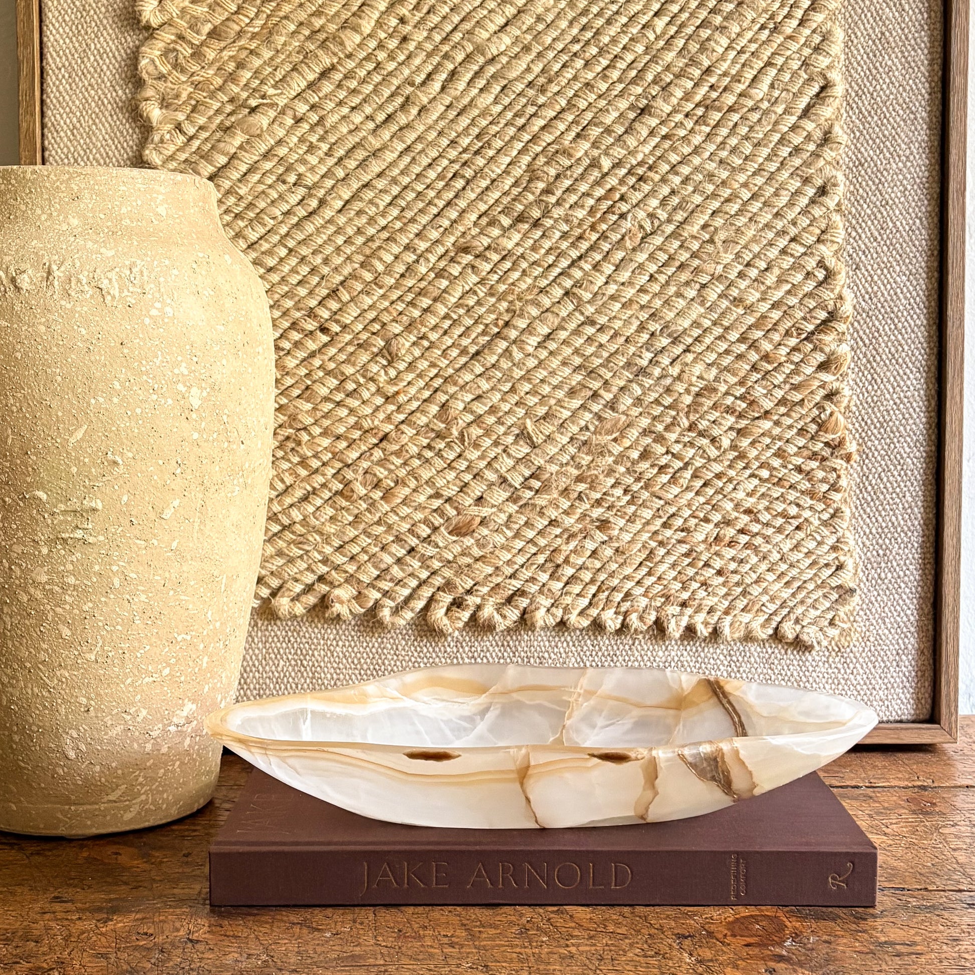 Decorative natural stone bowl on a book with a textured wall in the background