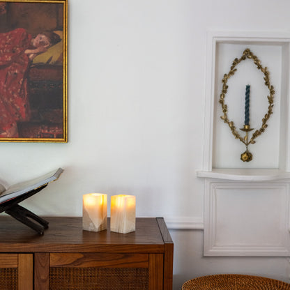 Warm glowing tealight candles in polished amber onyx holders