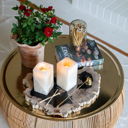 Pair of glowing amber onyx tealight candle holders displayed on a luxury gold coffee table with floral décor