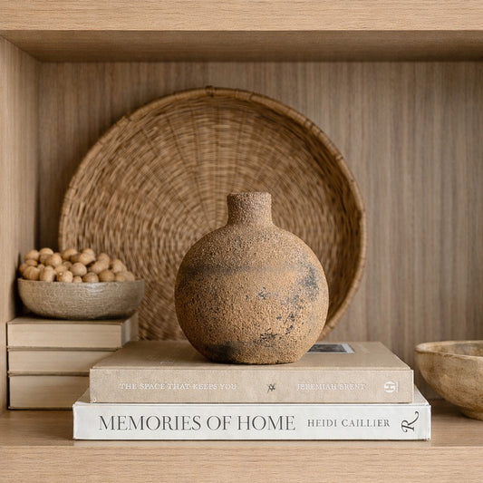 Handcrafted apple-shaped ceramic vase in earthy brown tones styled on wooden shelf with neutral home decor