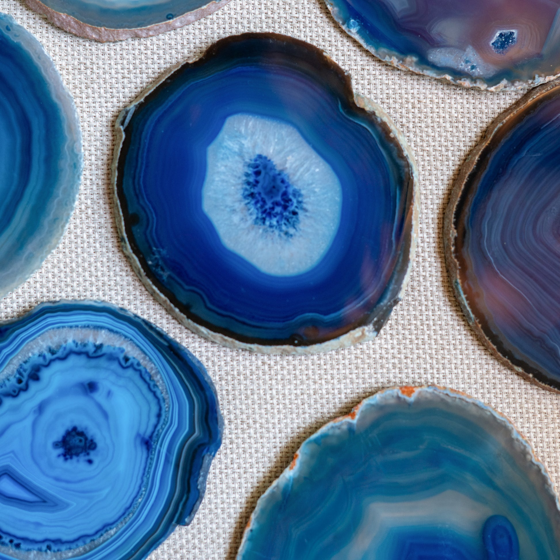 Luxury Brazilian agate coaster set in vibrant blue with natural crystalline formations and organic banding.