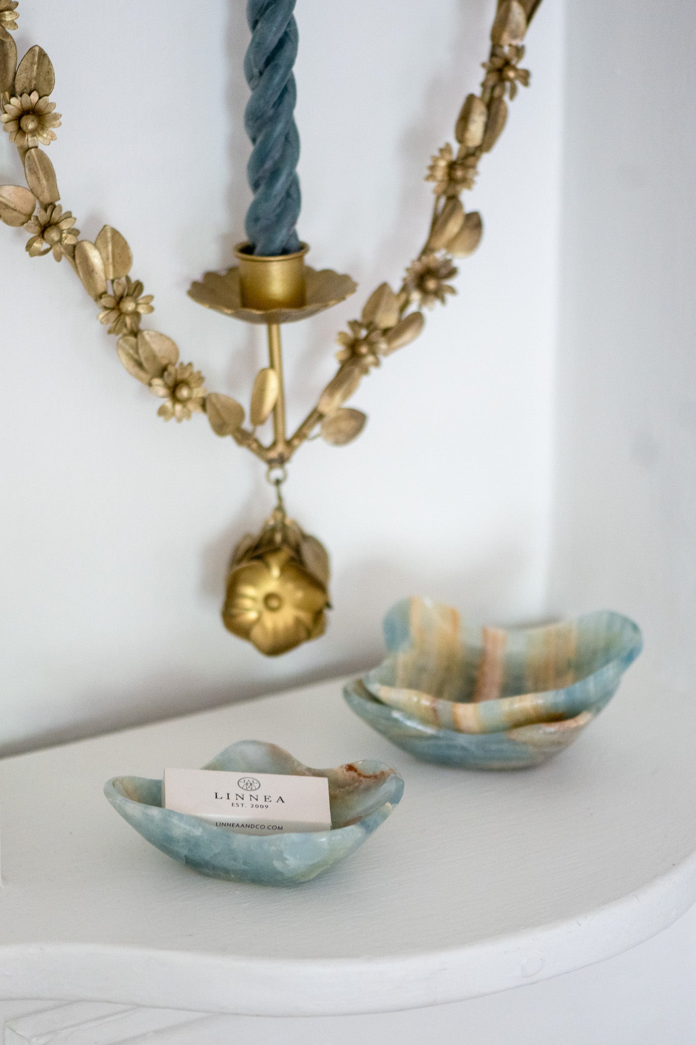 Modern blue onyx catchall tray styled with brass candle holder and neutral décor