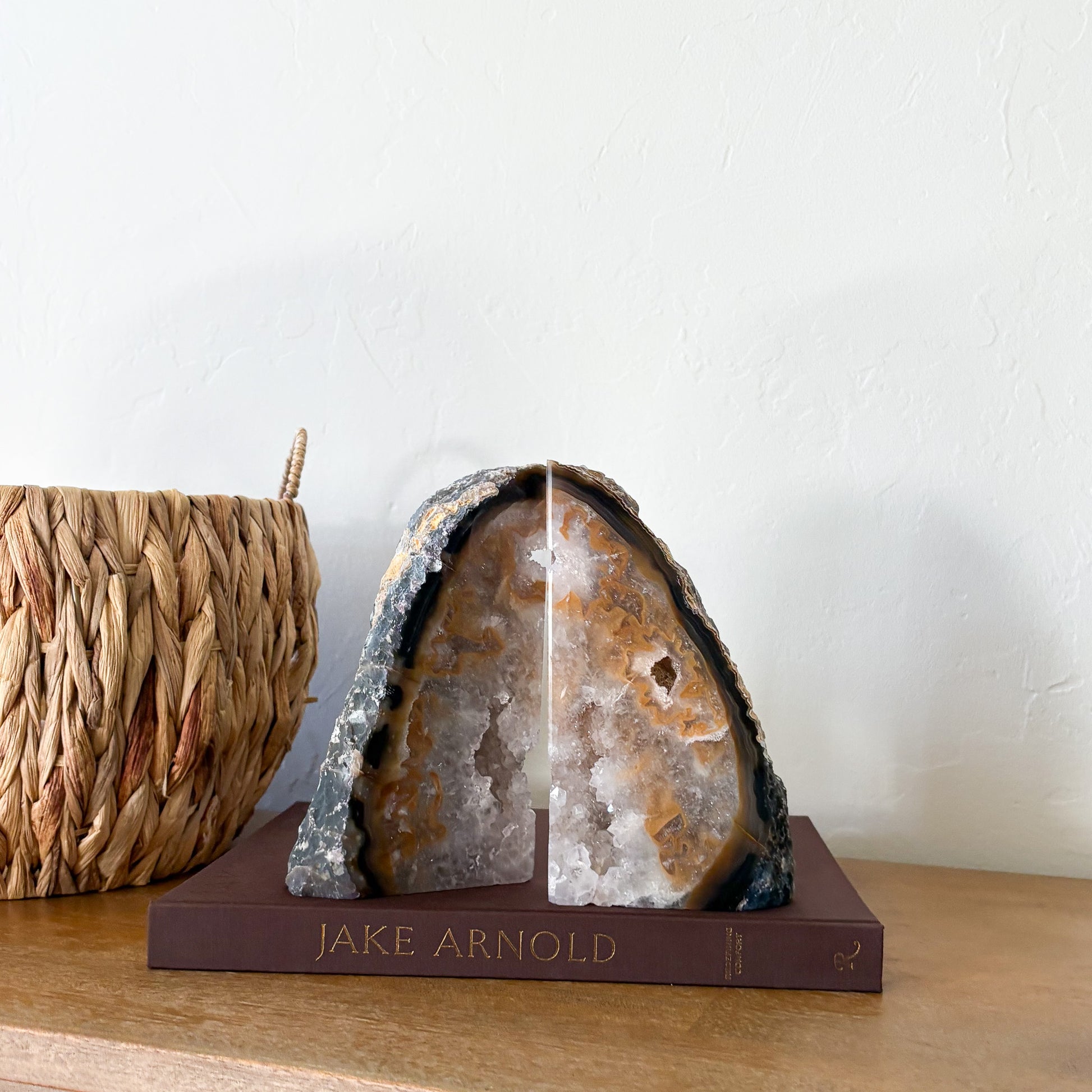 Brazilian agate geode bookend pair with warm caramel banding and natural quartz crystal center on decorative book