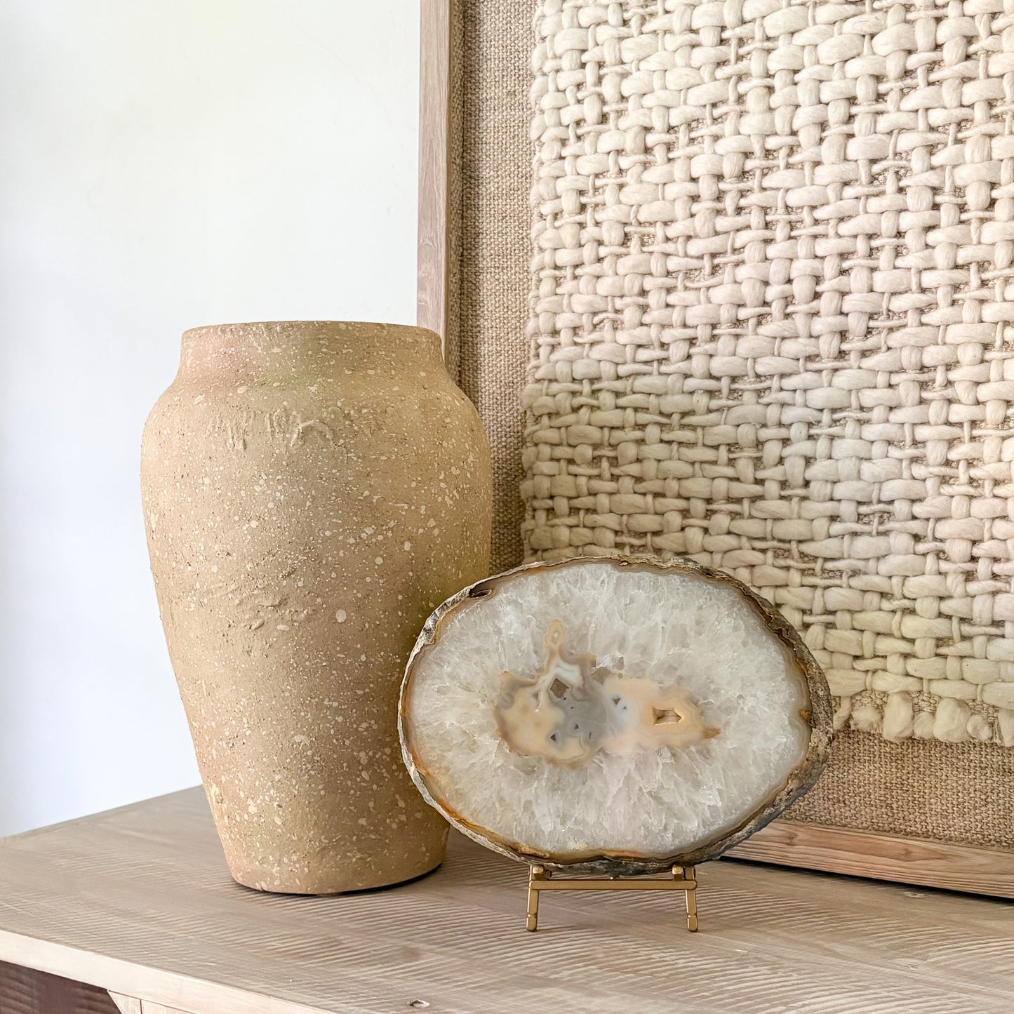 Decorative agate stone sculpture on a wooden surface with a textured wall in the background
