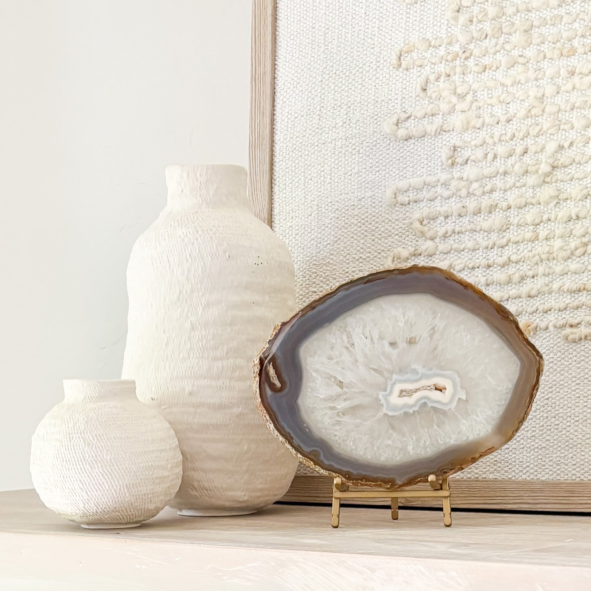 Handcrafted Brazilian agate slice featuring colorful mineral layers displayed on a stylish stand.