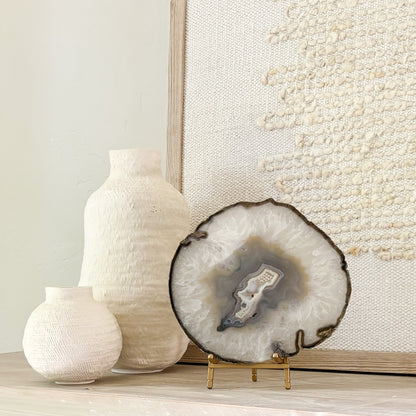 Handcrafted Brazilian agate slice featuring colorful mineral layers displayed on a stylish stand.