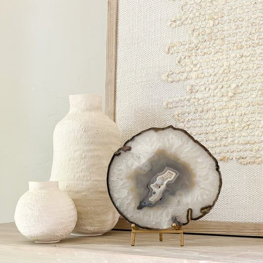 Handcrafted Brazilian agate slice featuring colorful mineral layers displayed on a stylish stand.