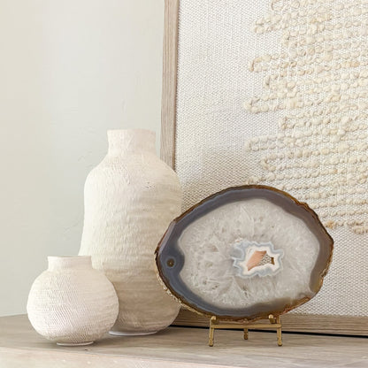 Brazilian agate slice on metal stand displaying natural crystal patterns as elegant home décor accent.