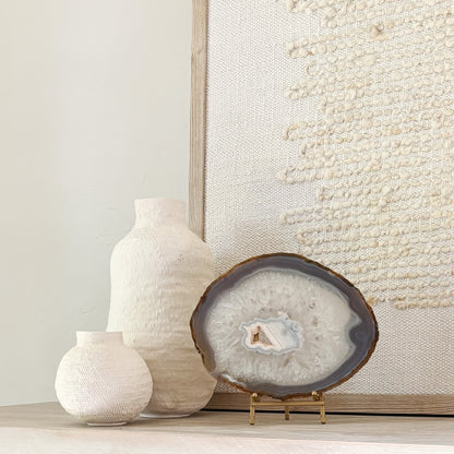 Handcrafted Brazilian agate slice featuring colorful mineral layers displayed on a stylish stand.