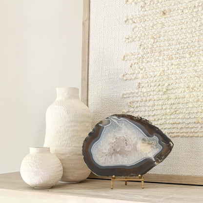 Large Brazilian agate slice sculpture on stand showcasing intricate geological formations for home decoration.