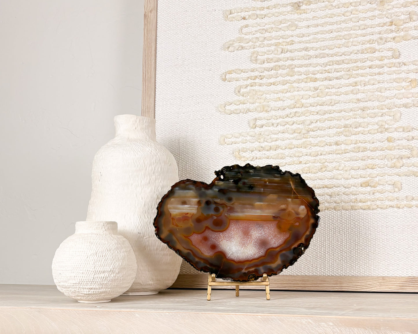 Natural Brazilian agate slice on stand with polished crystal bands and unique gemstone patterns.
