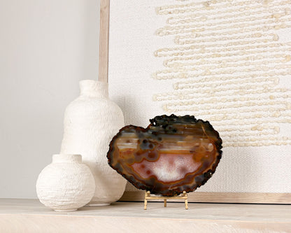 Natural Brazilian agate slice on stand with polished crystal bands and unique gemstone patterns.