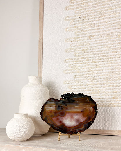 Brazilian agate crystal slice on display stand featuring natural banded stone formations