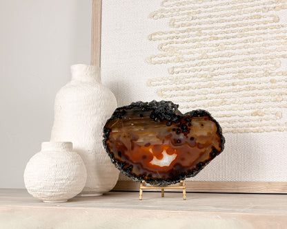 Polished Brazilian agate slice with natural crystal details displayed on a decorative stand