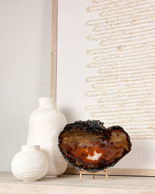 Natural Brazilian agate slice on display stand featuring unique crystal banding and polished stone patterns