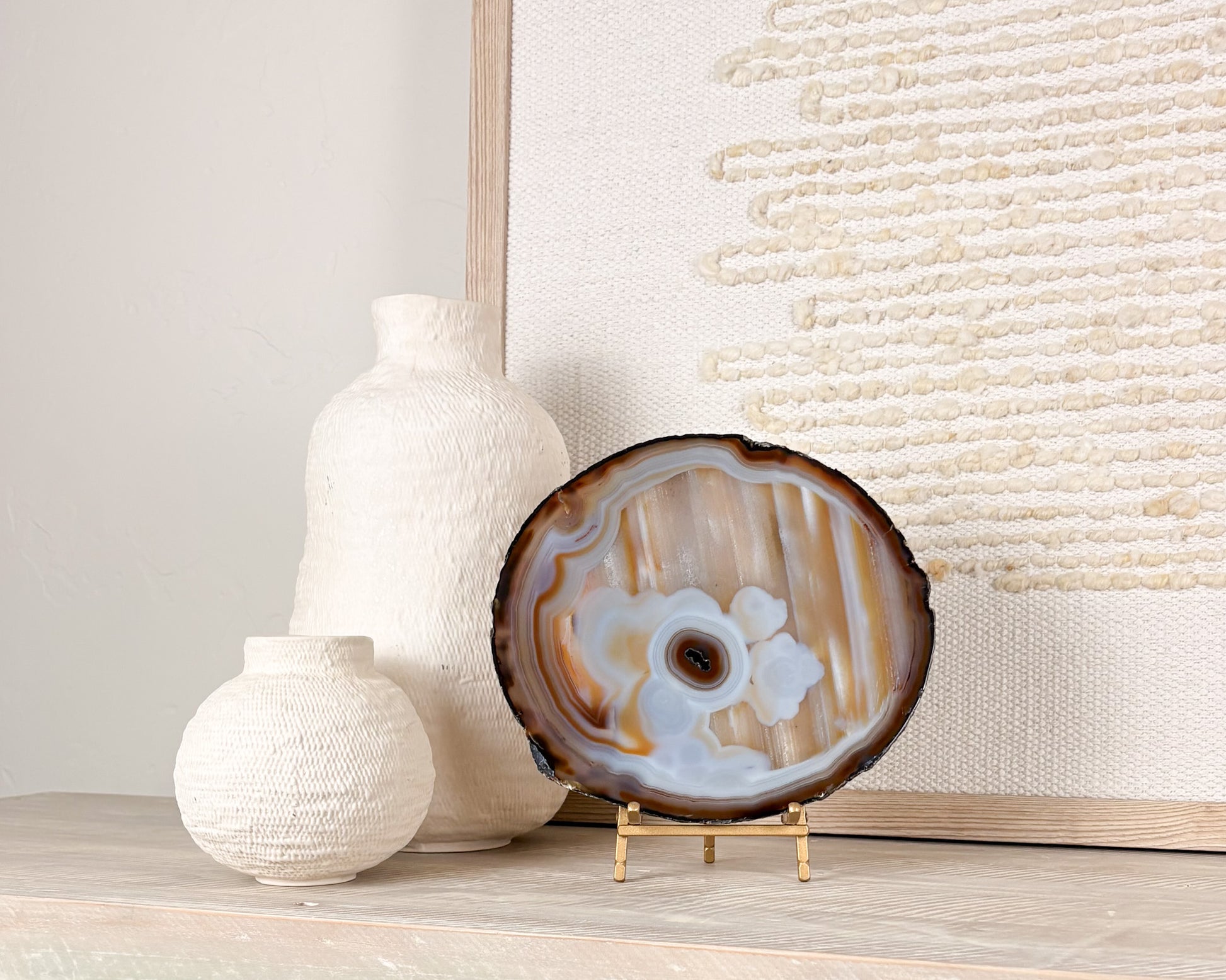 Polished Brazilian agate slice with natural crystal details displayed on a decorative stand