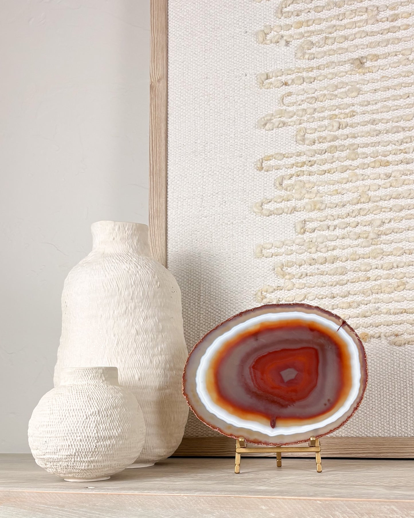 Natural agate slice from Brazil displayed on stand with intricate mineral banding and crystal texture