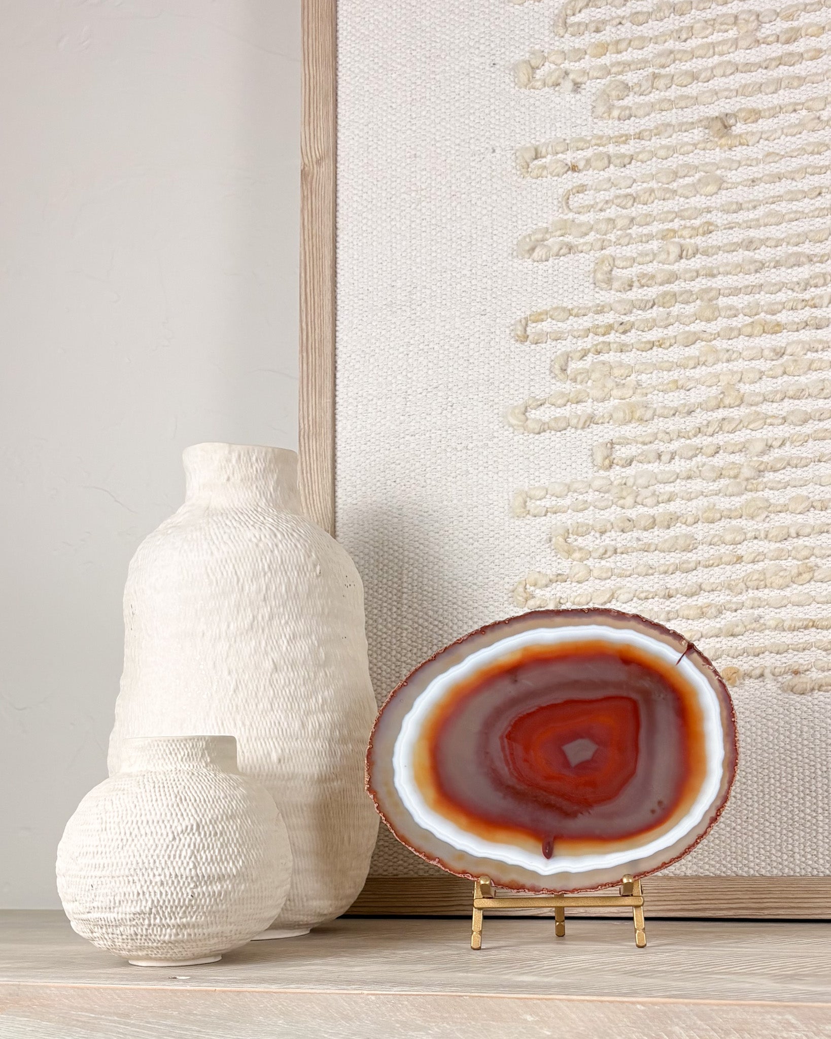 Natural agate slice from Brazil displayed on stand with intricate mineral banding and crystal texture