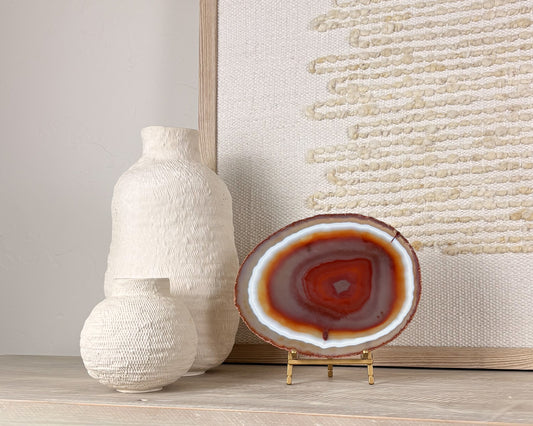 Unique Brazilian agate slice with colorful natural banding mounted on a display stand.