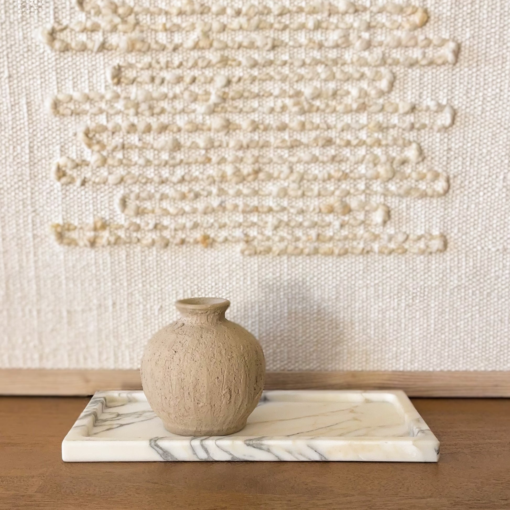 Calacatta Vagli marble tray with white surface and dramatic gray veining on wood table