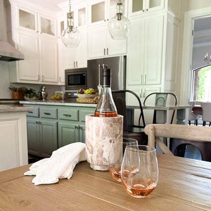 Natural marble wine cooler with rosé wine bottle and glasses in an elegant modern kitchen