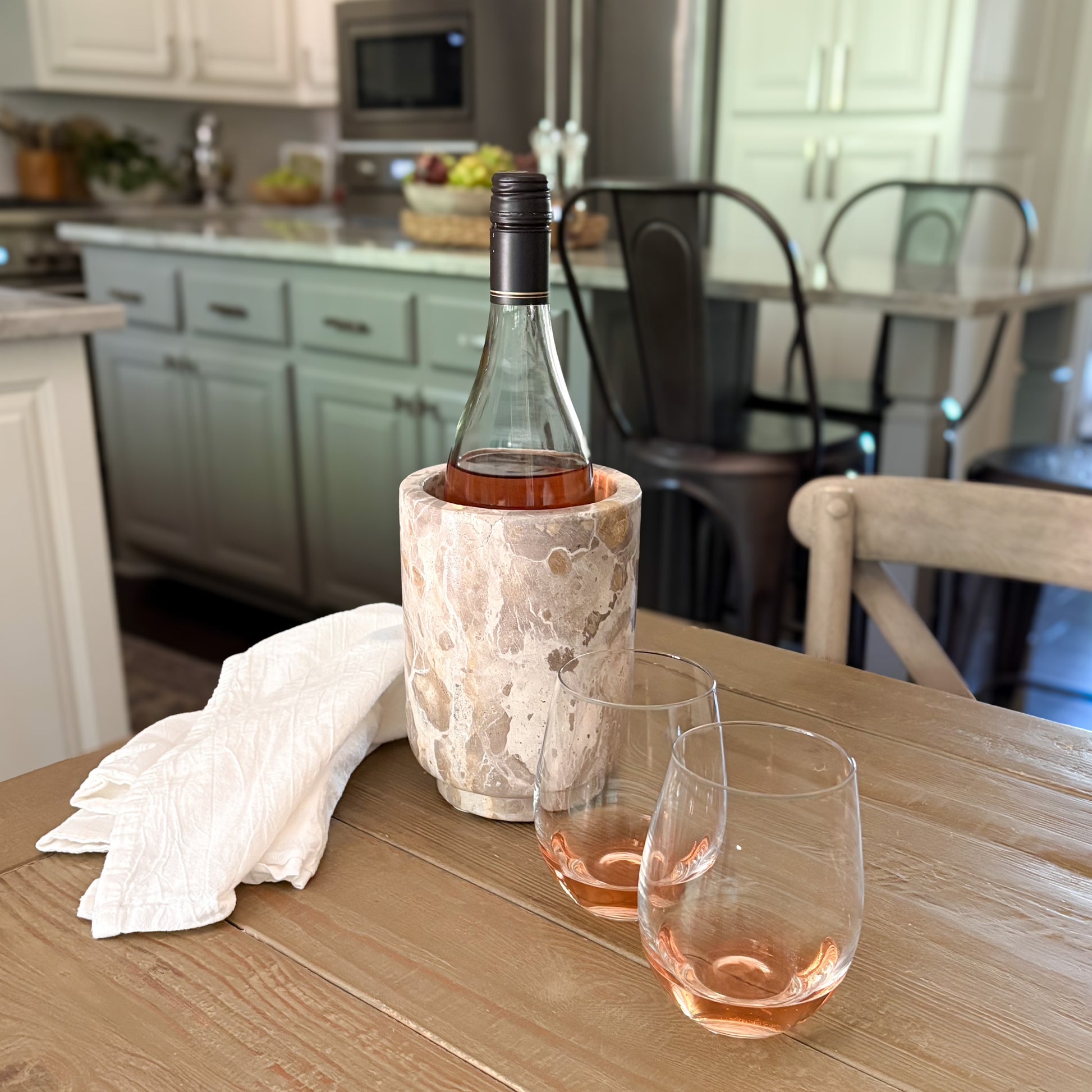 Luxury Chamonix marble wine chiller displayed on a rustic wood table with wine glasses
