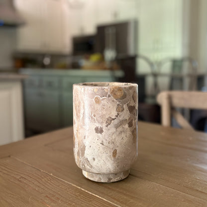 Natural stone wine cooler with unique marble veining and rosé wine bottle