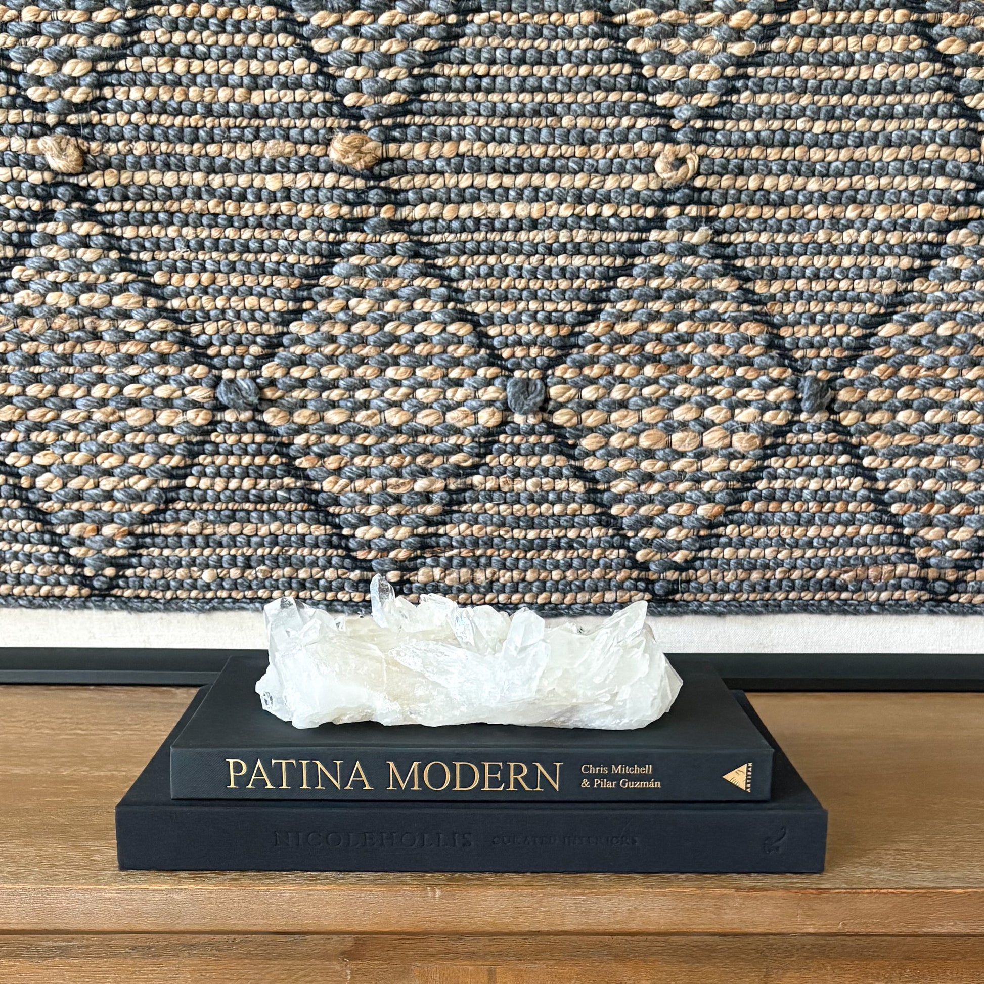 Clear quartz crystal cluster on wooden table in modern organic living room