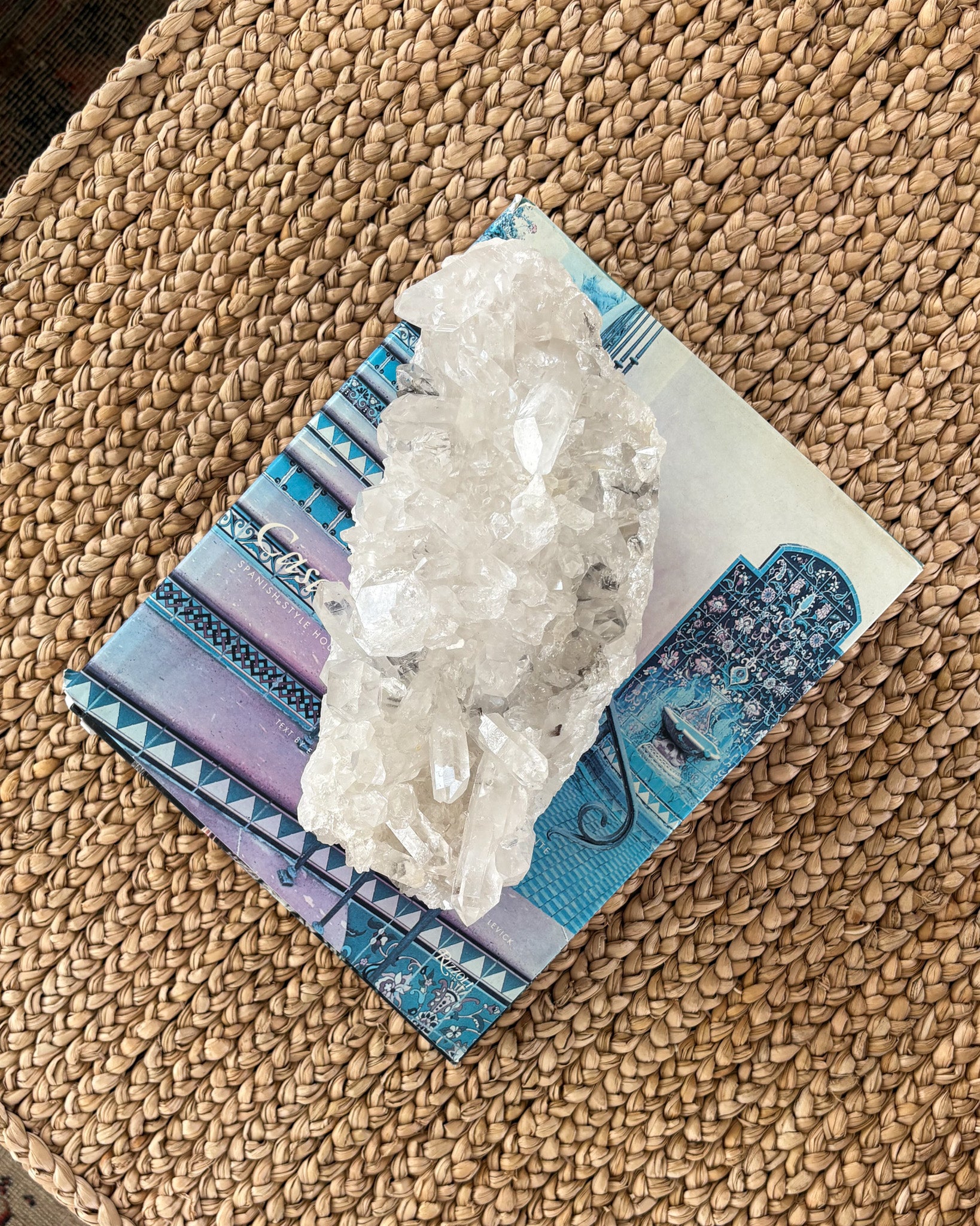 Raw clear quartz crystal cluster displayed on a shelf as luxury decor
