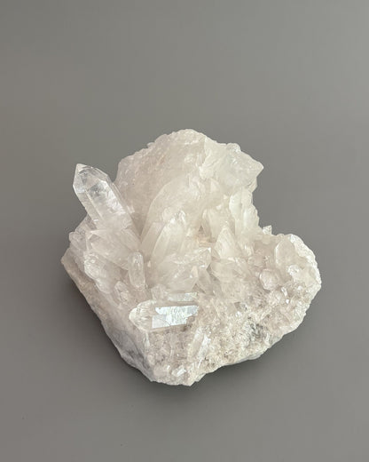 One-of-a-kind clear quartz cluster with intricate crystal formations and natural mineral texture.